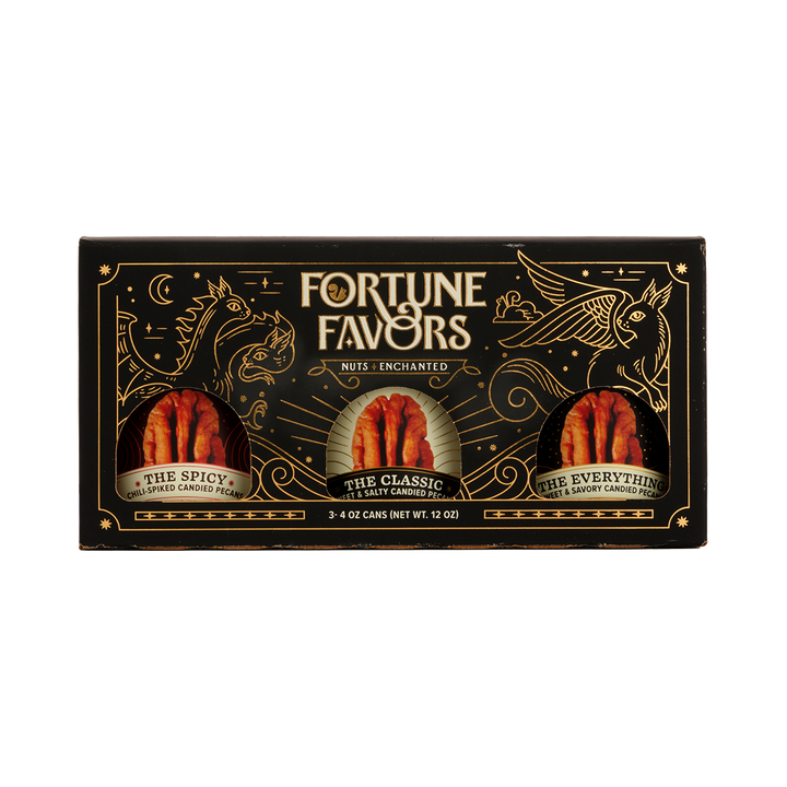Black and gold sampler gift pack containing three 4 ounce cans of Fortune Favors candied pecans, one of each signature flavor.