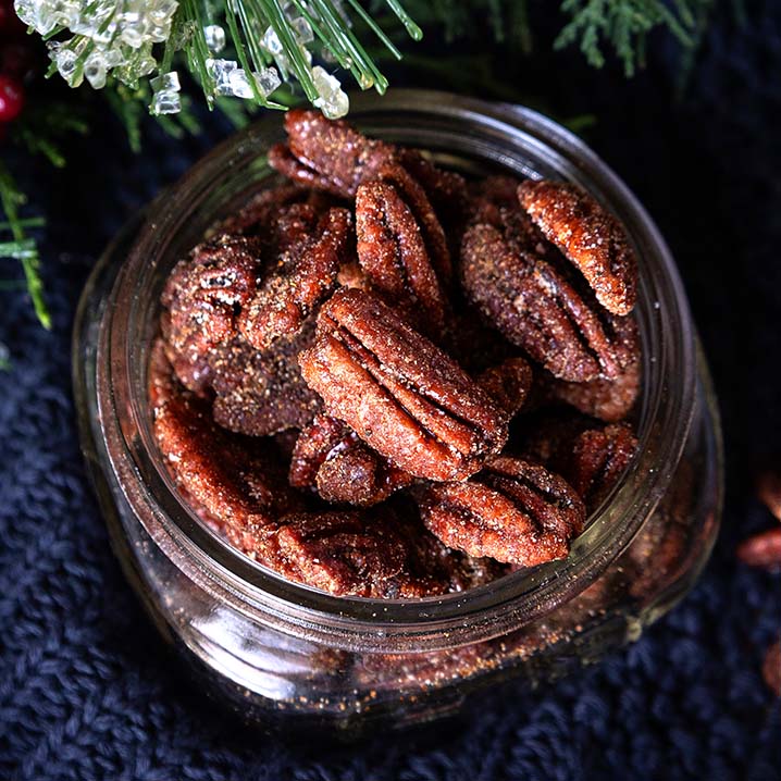 dish of Fortune Favors Sweater Weather spiced and sweet candied pecans with holiday decorations